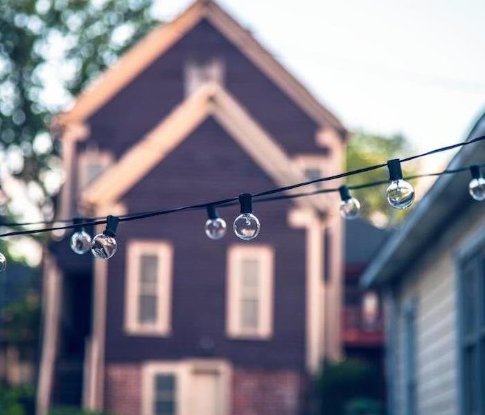 string lights with a house in the background